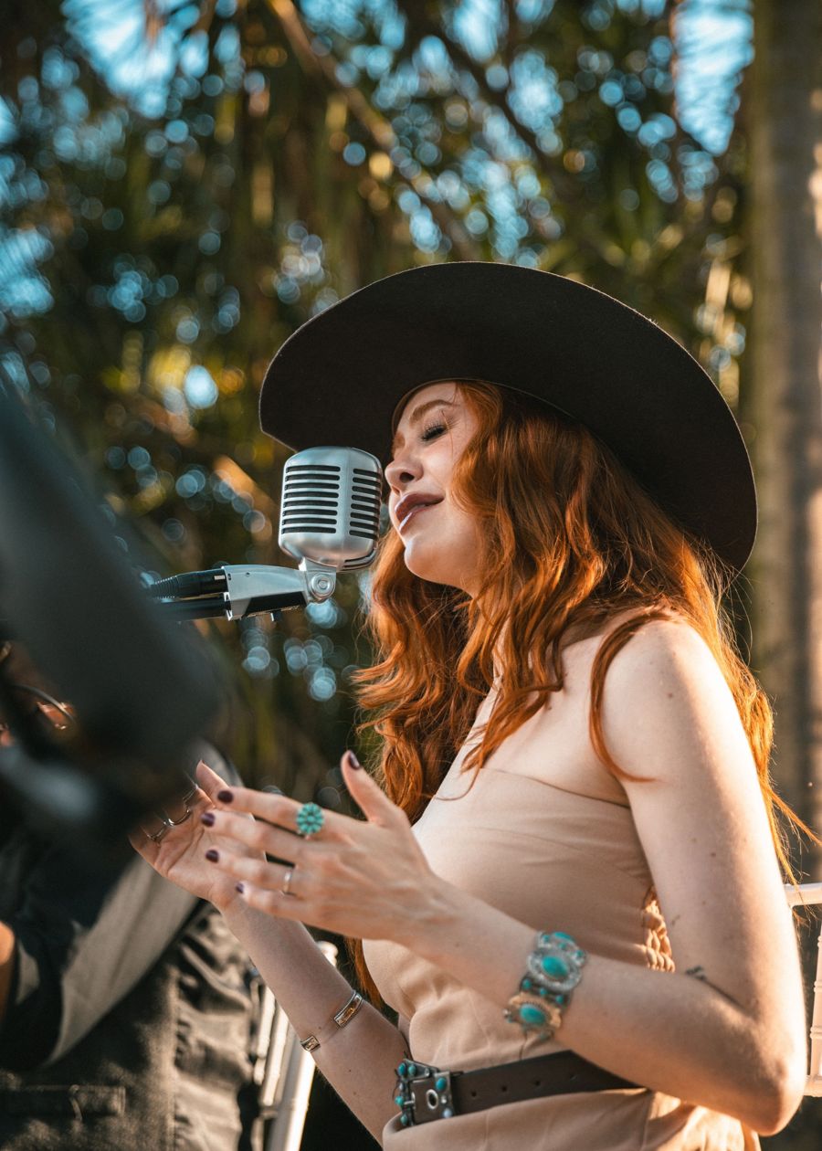 Sofia Gayoso cantando de chapéu na cerimônia