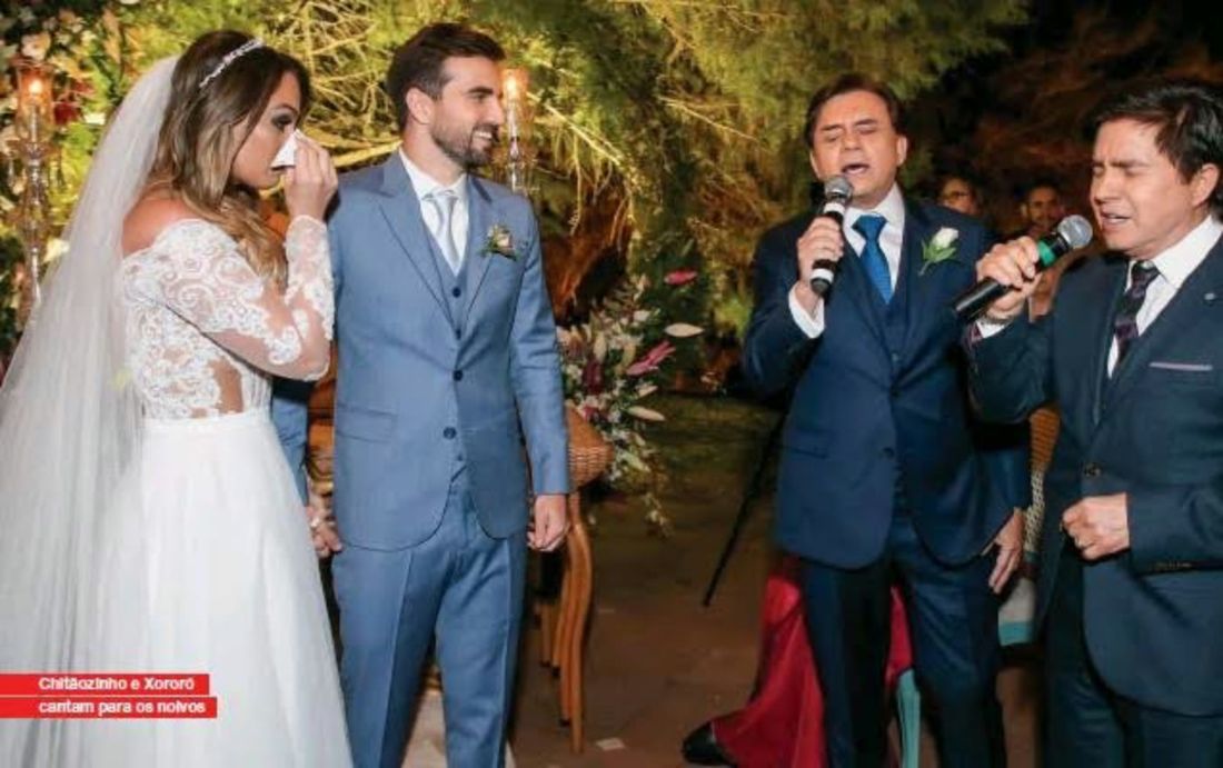 Chitãozinho e Xororó cantando com a banda em um casamento